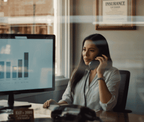 Independent insurance agent on a call with an AI-powered quote comparison on screen in a small-town agency office